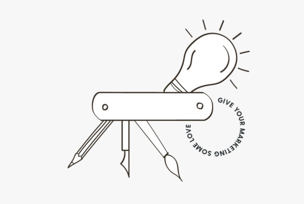 Light bulb and pens with text that says give your marketing some love