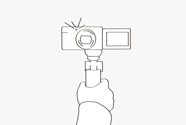 An illustration of a hand holding a video camera on a blog about vlogging